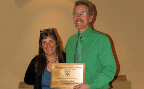 Sheppard holding the award plaque