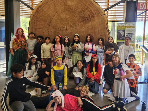 Dr. Pamela Pelletier and the Hendrick students in front of the Giant Sequoia, dressed up to celebrate Halloween.